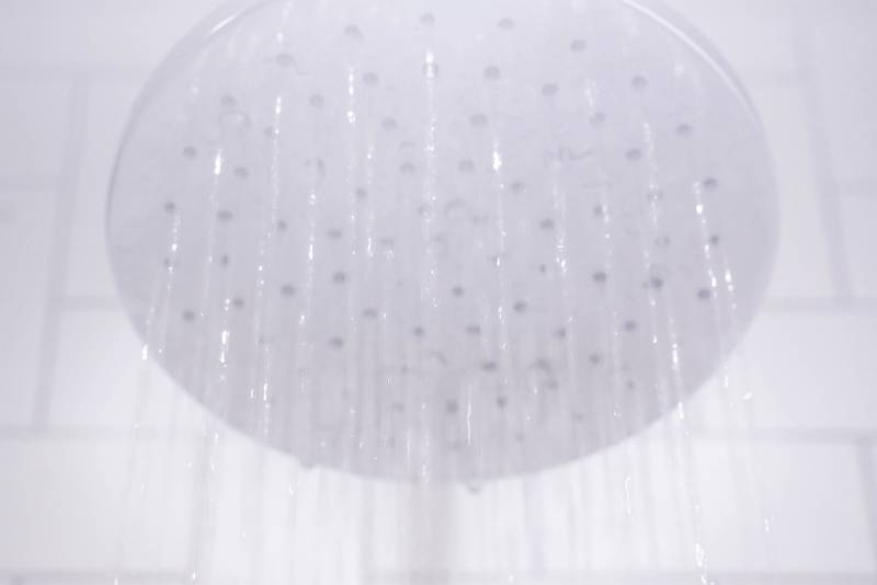 Close-up shot of showerhead in steamy bathroom